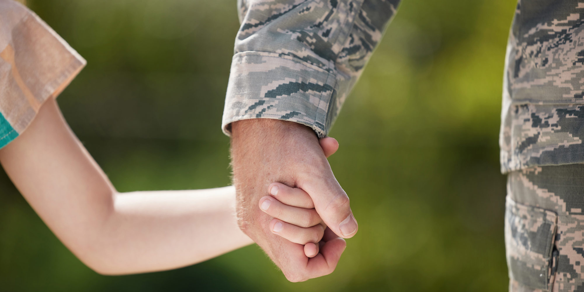 daughter holding father in military hand