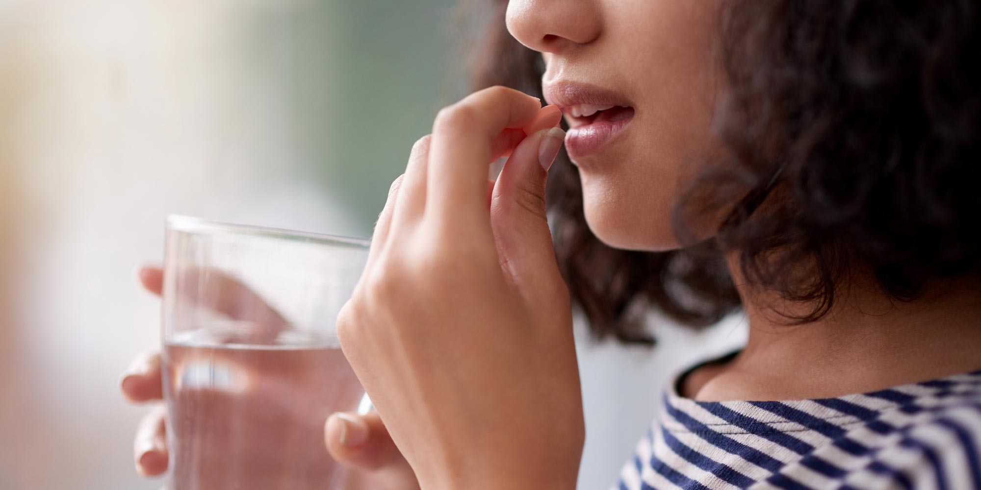 cropped shot of girl drinking zantac medication