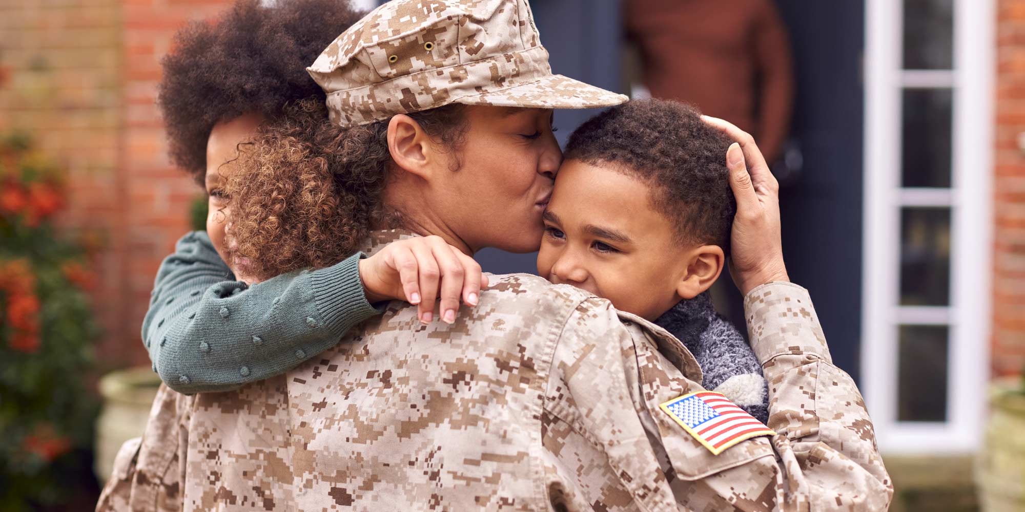 soldier mother hugging children